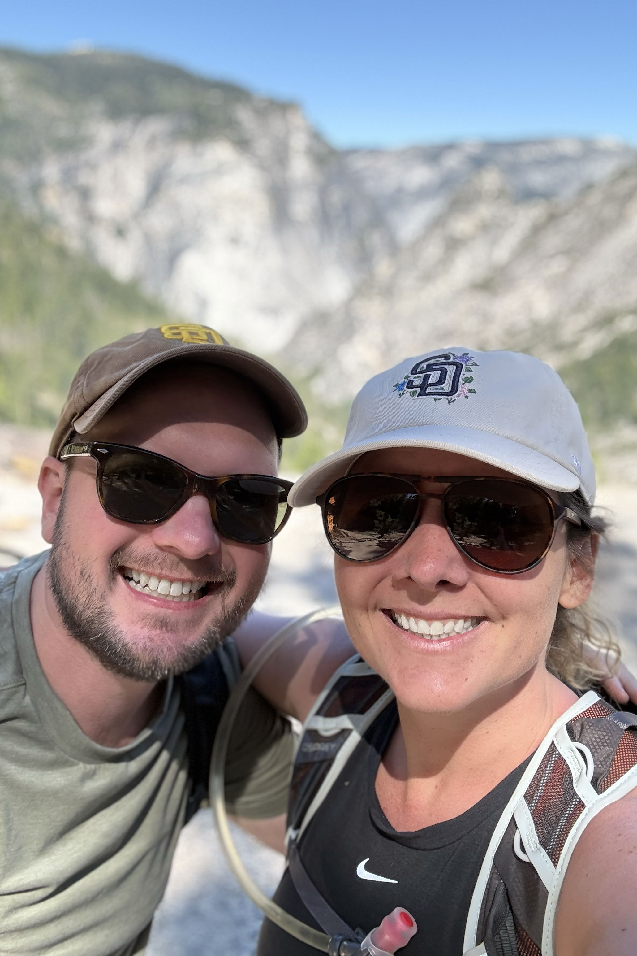 Kris and Liam smiling together on a hike